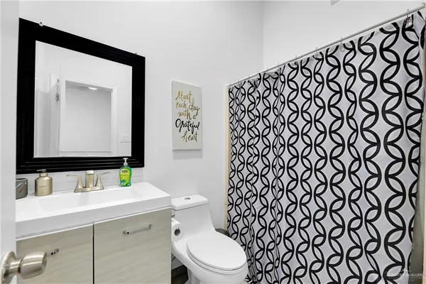 a bathroom with a sink mirror vanity and toilet