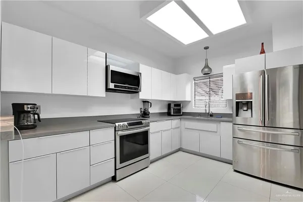 a kitchen with white cabinets stainless steel appliances and a sink