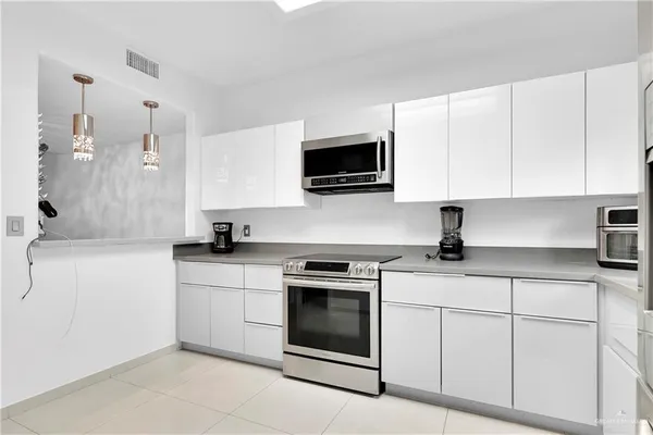 a kitchen with white cabinets and white appliances