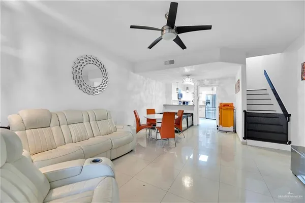 a living room with furniture and a ceiling fan