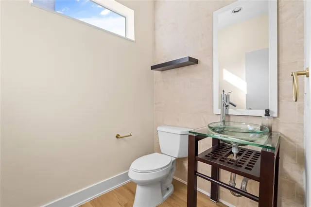 a bathroom with a sink a toilet and a mirror