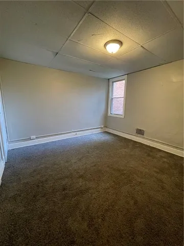 an empty room with an entryway and windows