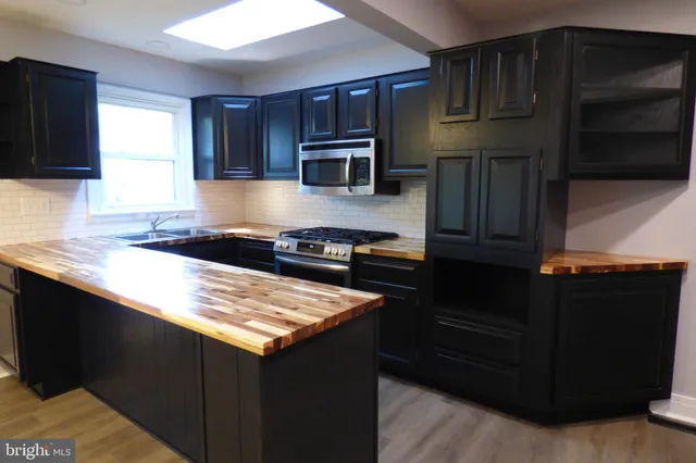 a kitchen with stainless steel appliances granite countertop a stove and a microwave