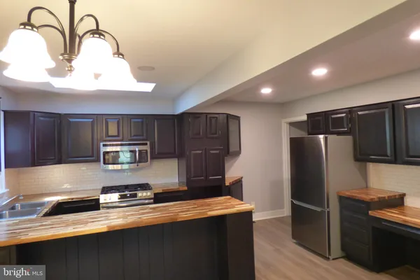 a kitchen with stainless steel appliances a refrigerator a sink a stove and cabinets