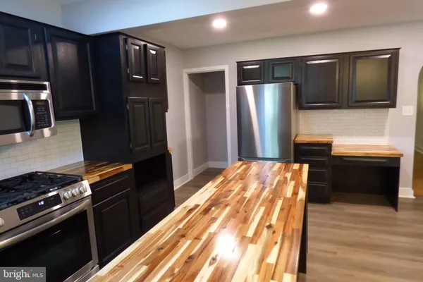 a kitchen with stainless steel appliances granite countertop a refrigerator and a stove