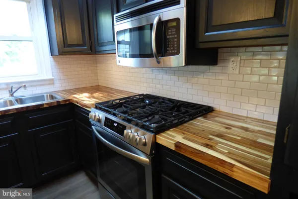 a stove top oven sitting inside of a kitchen