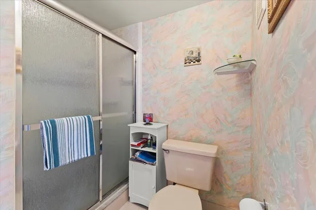 a white toilet sitting next to a bathroom sink