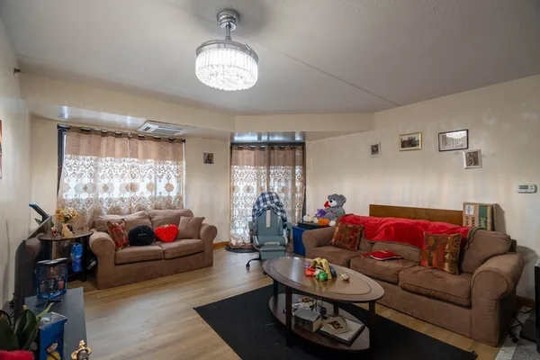 a living room with furniture a chandelier and a window