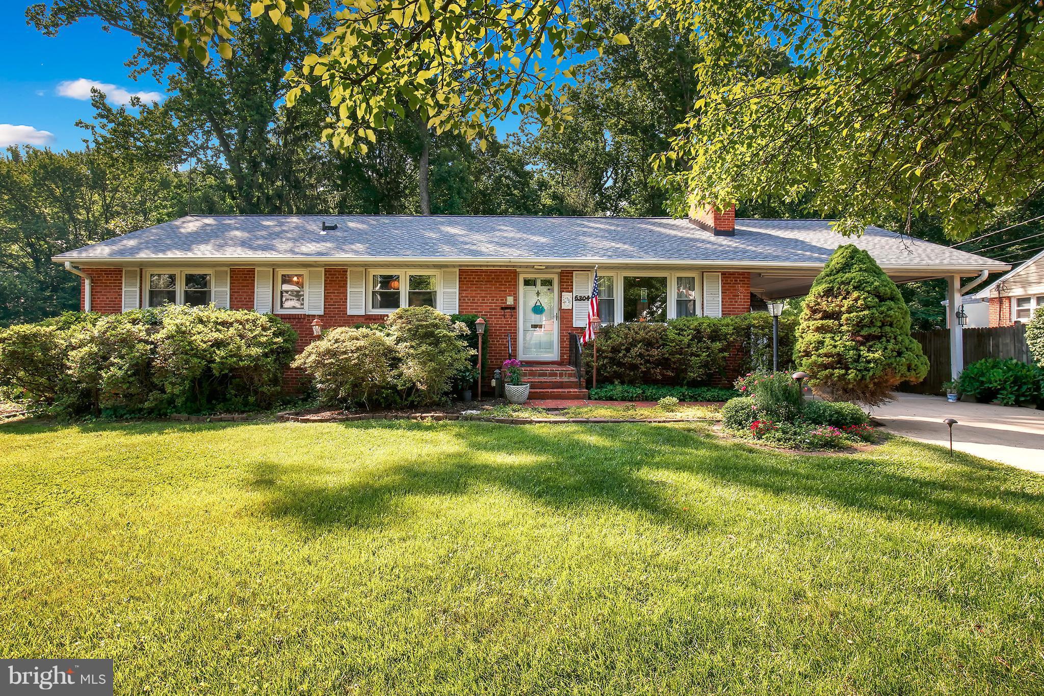 5304 Ravensworth Road Springfield, VA 22151 - Photo 1 of 30 a view of a house in front of a big yard with plants and large trees
