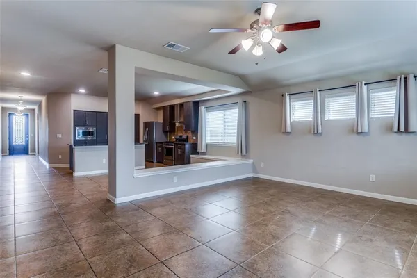 a view of a livingroom with a chandelier fan and windows