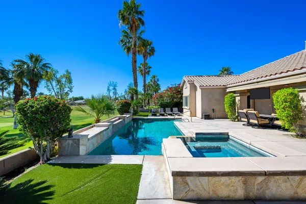 a view of a house with swimming pool and sitting area