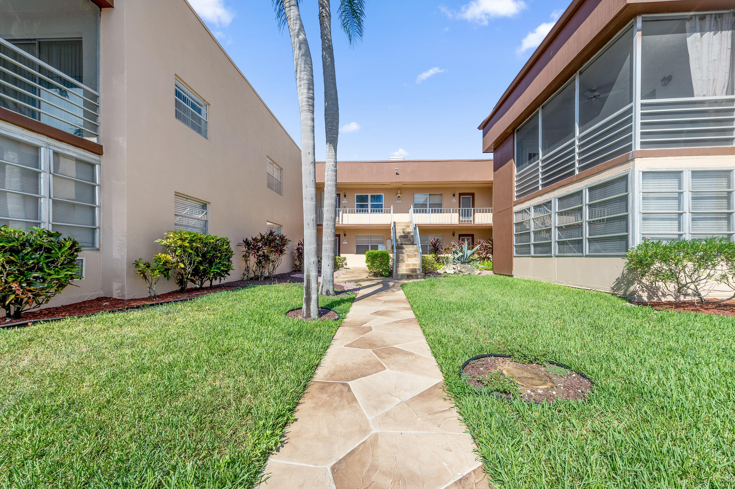488 Burgundy P Delray Beach, FL 33484 - Photo 21 of 33 a front view of a house with a yard and potted plants