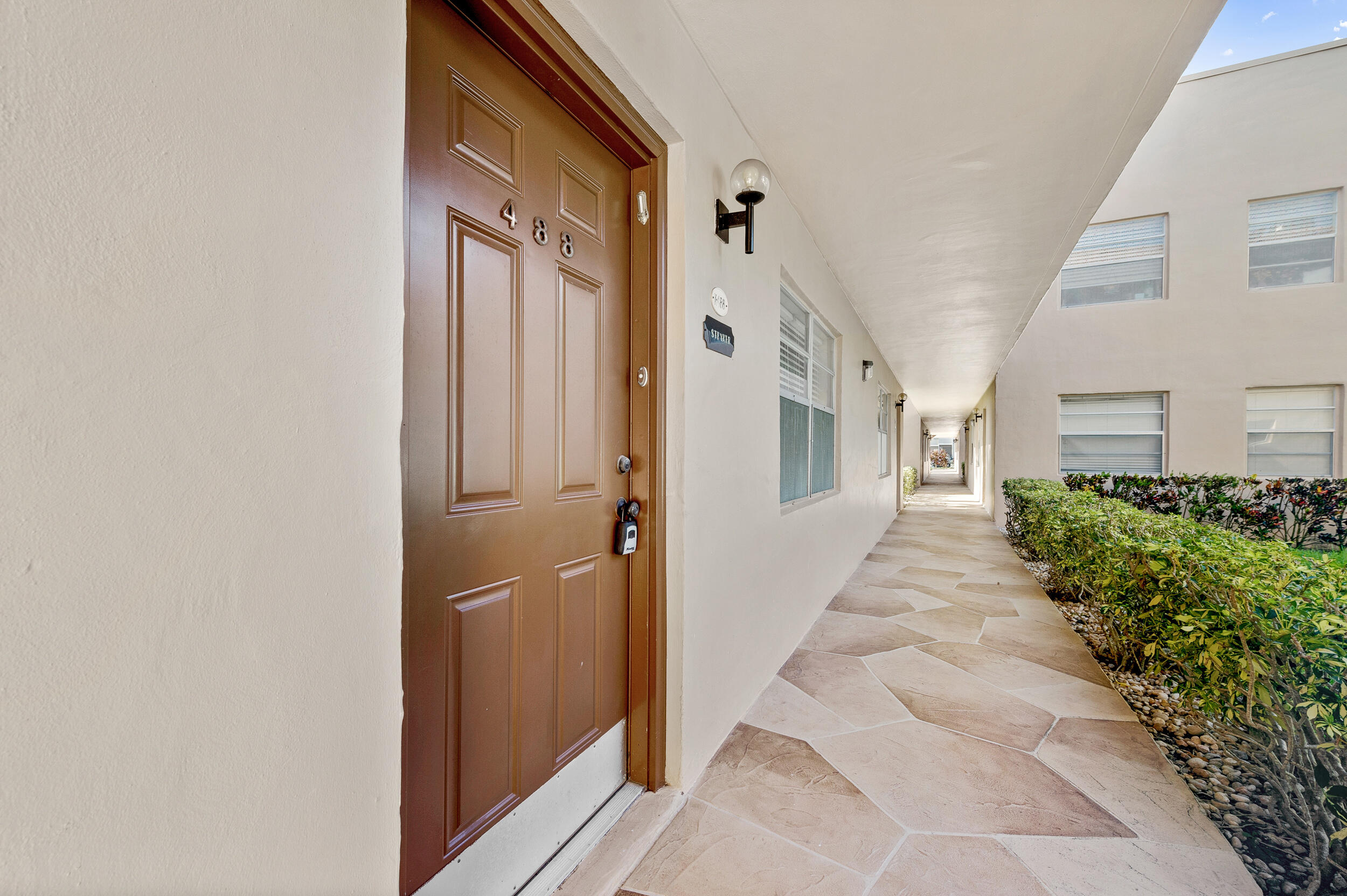 488 Burgundy P Delray Beach, FL 33484 - Photo 31 of 33 a view of a pathway along the house