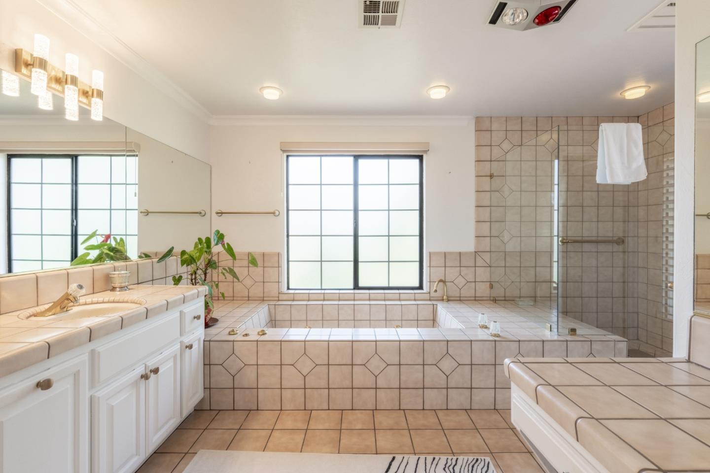 1043 Broncho Road Pebble Beach, CA 93953 - Photo 14 of 21 a bathroom with a granite countertop bathtub a sink and a shower