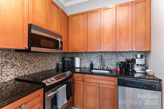a kitchen with stainless steel appliances granite countertop a stove microwave and sink