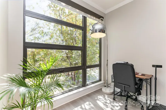a view of a workspace with furniture and a window