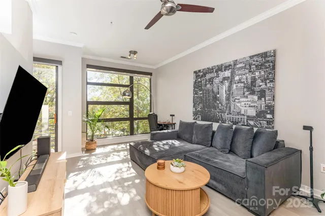 a living room with furniture a flat screen tv and a large window
