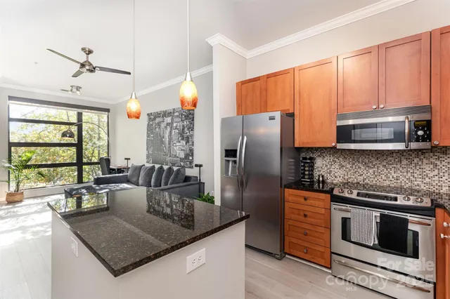 a kitchen with stainless steel appliances granite countertop a sink stove and refrigerator