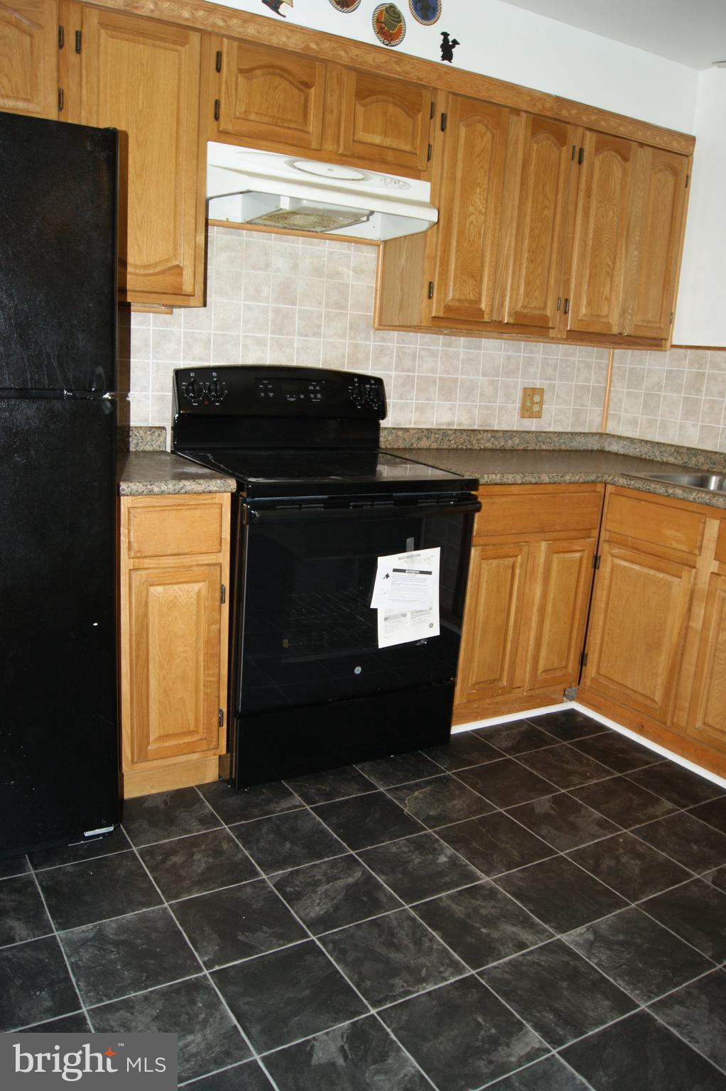 837 North Central Avenue Baltimore, MD 21202 - Photo 5 of 25 a kitchen with a sink a stove and black cabinets