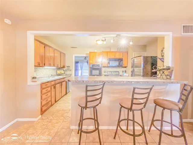 a kitchen with stainless steel appliances kitchen island granite countertop a sink and cabinets