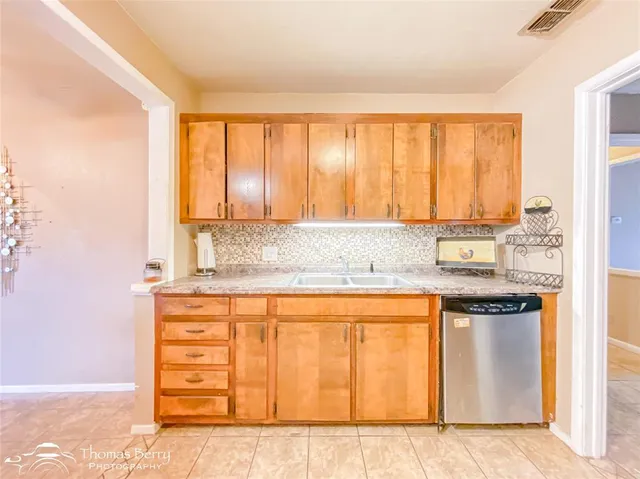 a kitchen with stainless steel appliances granite countertop a sink and a window