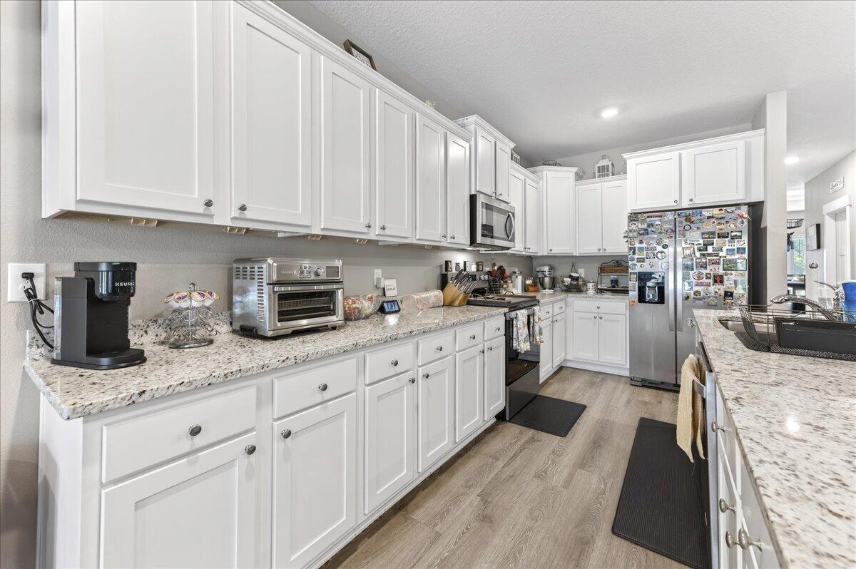 2455 Dakota Way Crestview, FL 32536 - Photo 19 of 81 a kitchen with stainless steel appliances granite countertop a stove a sink and white cabinets