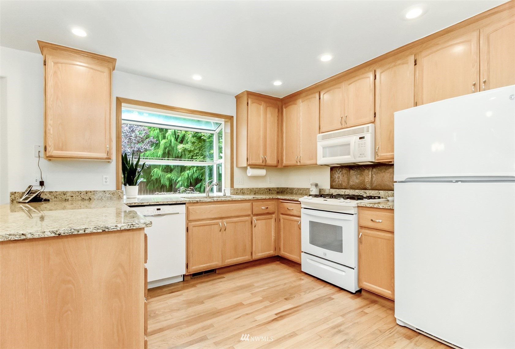 25815 176th Place Southeast Covington, WA 98042 - Photo 15 of 36 a kitchen with granite countertop white cabinets and white appliances
