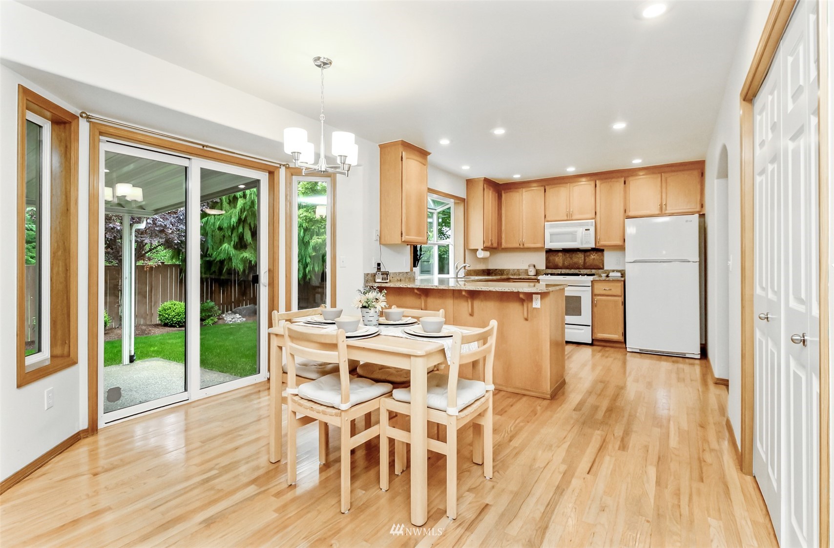 25815 176th Place Southeast Covington, WA 98042 - Photo 18 of 36 a kitchen with stainless steel appliances a dining table chairs and wooden floor