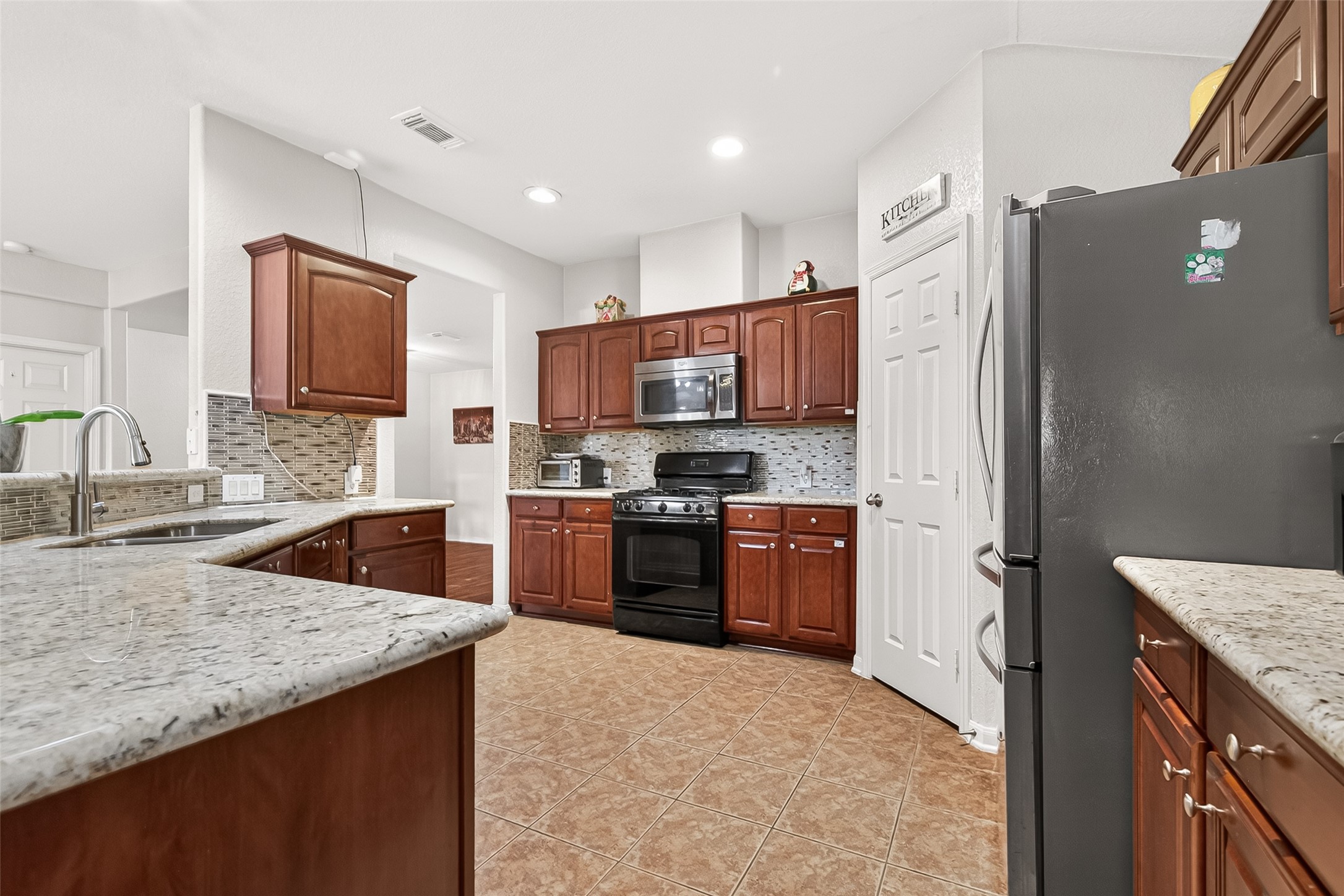 16715 Mackenzie Mesa Drive Spring, TX 77379 - Photo 13 of 50 a kitchen with stainless steel appliances granite countertop a refrigerator stove and sink