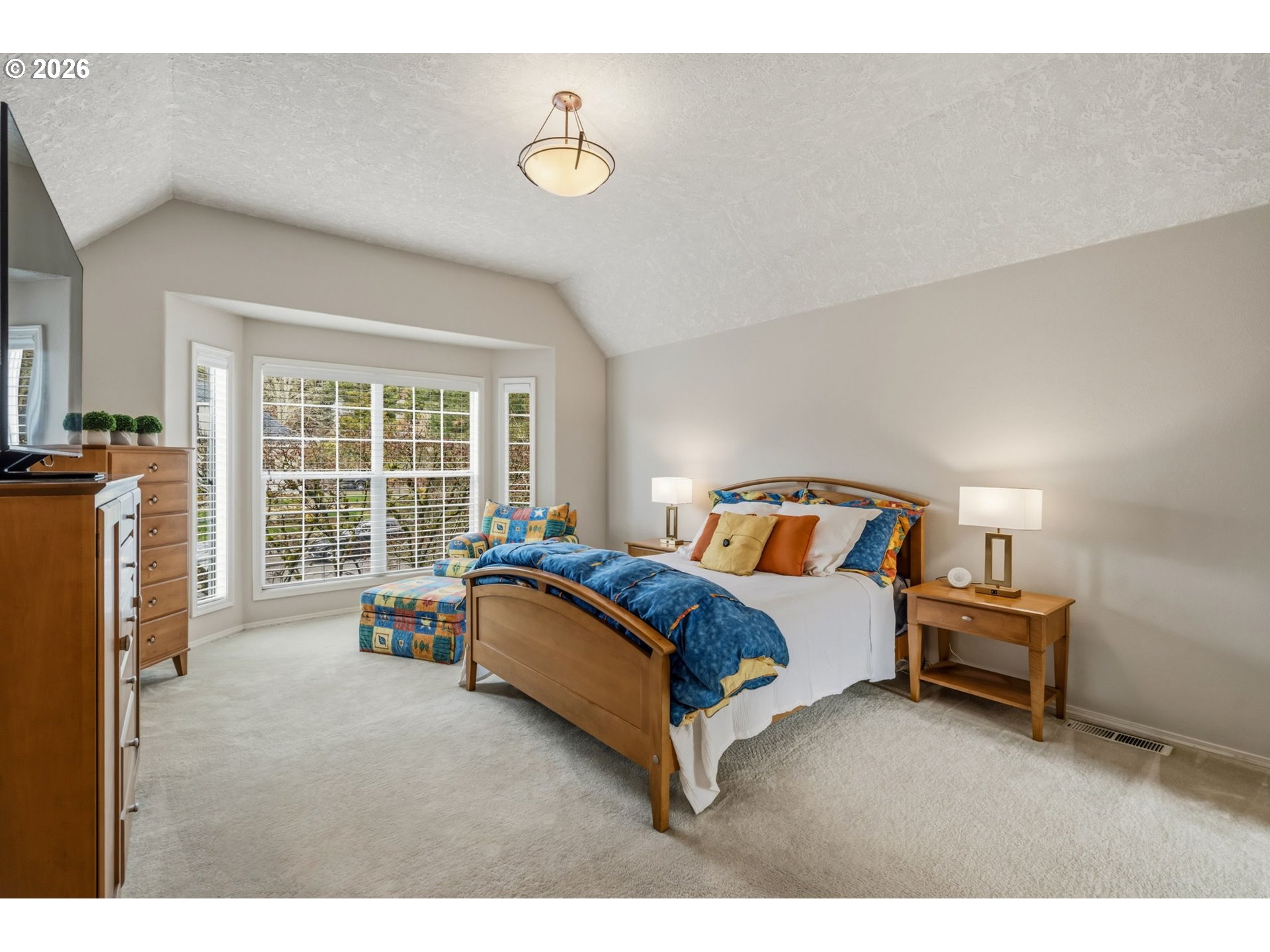 6108 Southwest Kruse Ridge Drive Portland, OR 97219 - Photo 21 of 42 a spacious bedroom with a bed and wooden floor