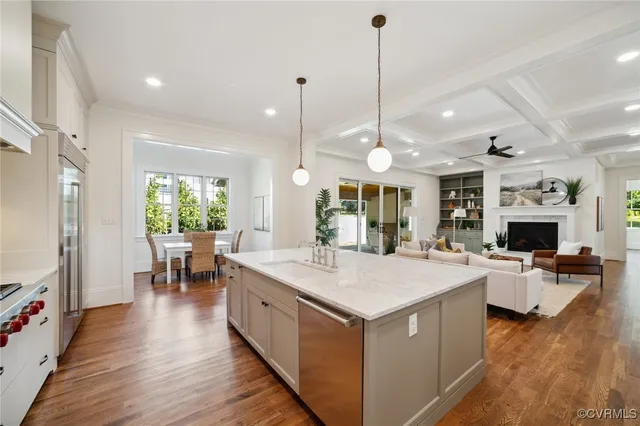 a large kitchen with kitchen island a island a stove a counter space dining table and a flat screen tv