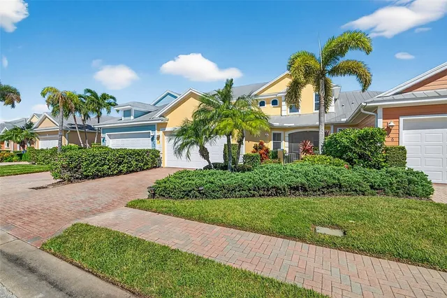 a front view of a house with a yard and potted plants