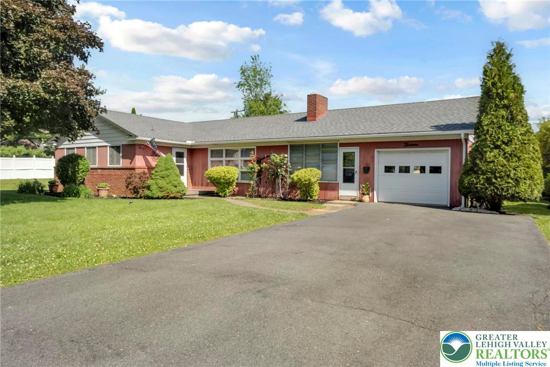 13 Ridgewood Road Easton, PA 18045 - Photo 2 of 32 A well-maintained ranch-style home features a spacious driveway and a charming front yard.