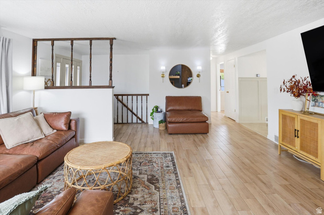 5108 South 2000th Street West Roy, UT 84067 - Photo 8 of 61 Living area featuring light wood-style flooring and a textured ceiling