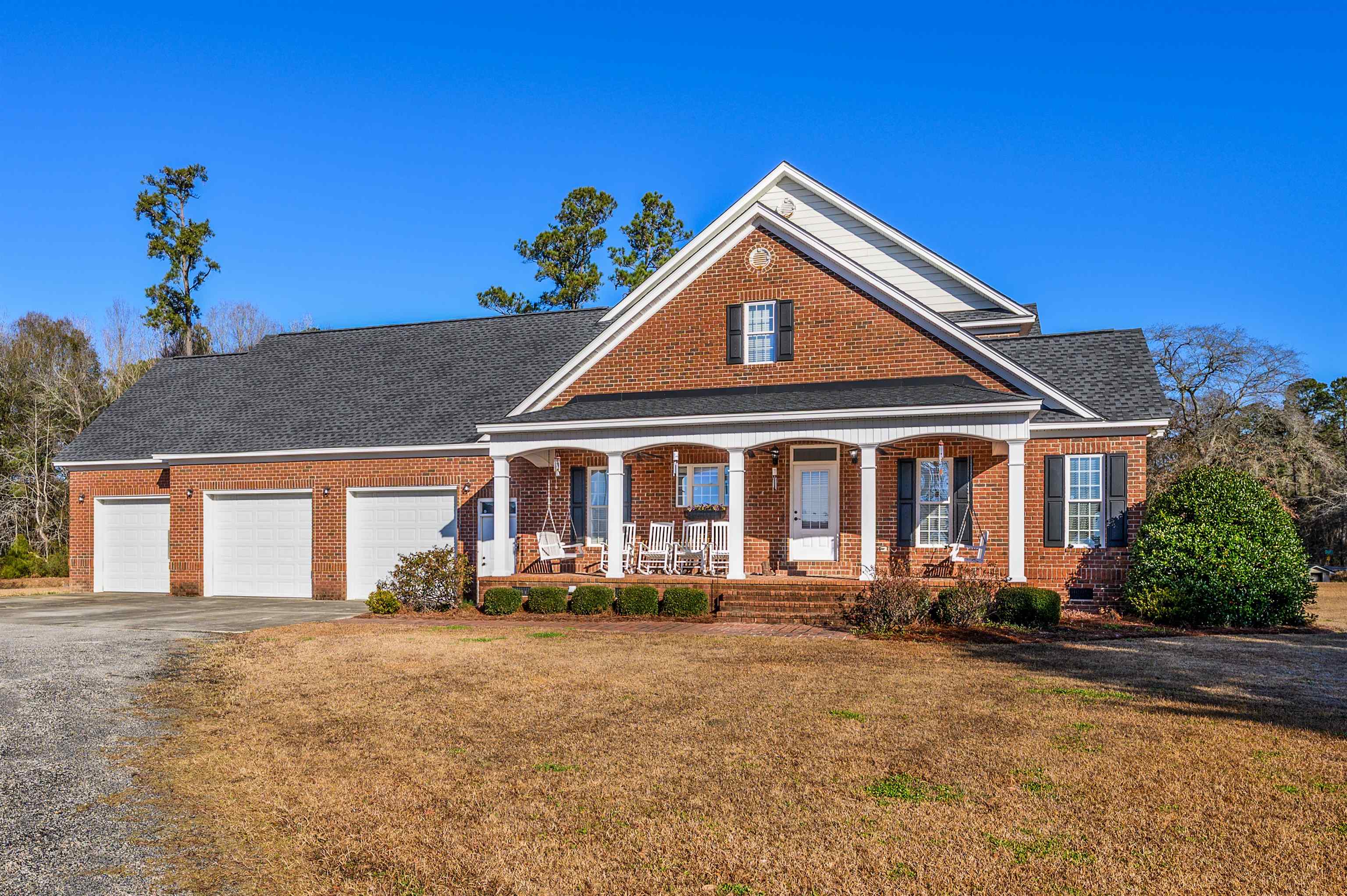 4310 Enoch Road Aynor, SC 29511 - Photo 31 of 39 View of front of house with brick siding, asphalt driveway, covered porch, a front yard, and an attached garage