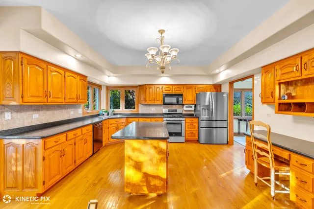 a large kitchen with stainless steel appliances granite countertop a sink and cabinets