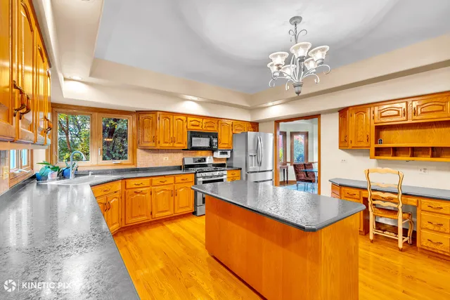 a large kitchen with a table chairs and flat screen tv