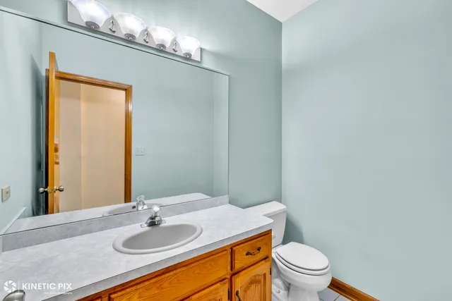 a bathroom with a granite countertop sink toilet and a mirror
