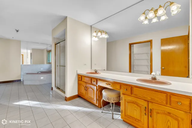 a spacious bathroom with a granite countertop sink a mirror and a bathtub