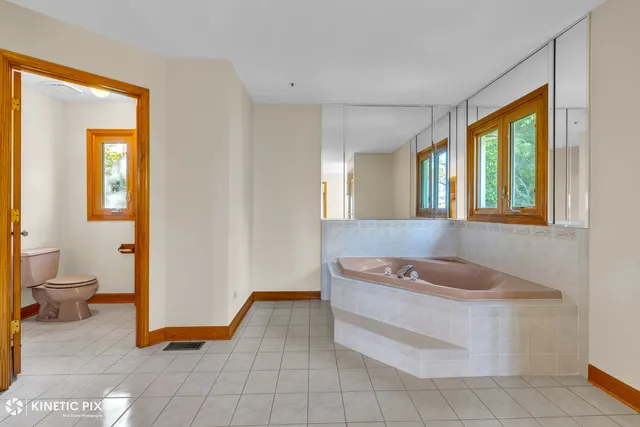 a spacious bathroom with a tub shower and a sink