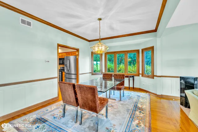 a dining room with furniture a chandelier and wooden floor