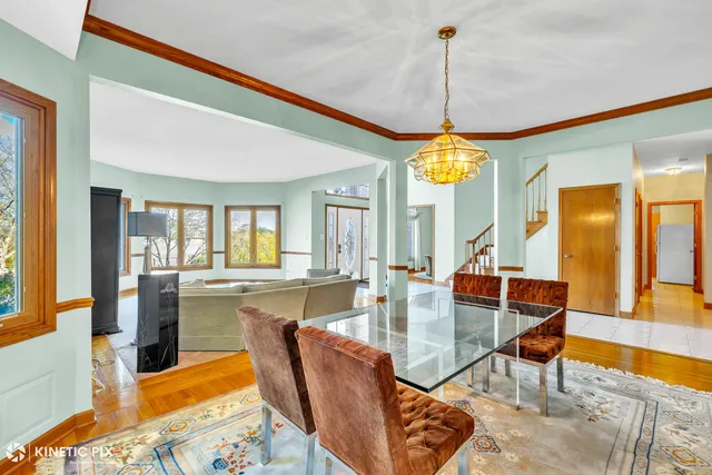 a dining room with furniture a chandelier and wooden floor