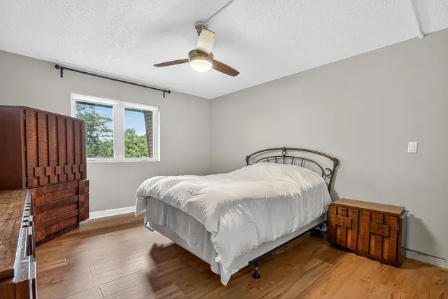 a bedroom with a bed and wooden floor
