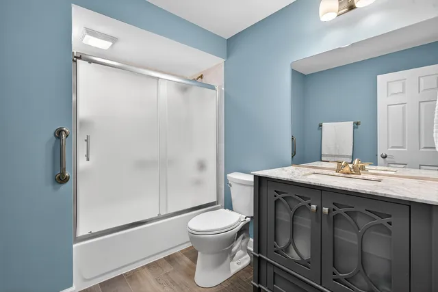 a bathroom with a granite countertop sink toilet a mirror and shower