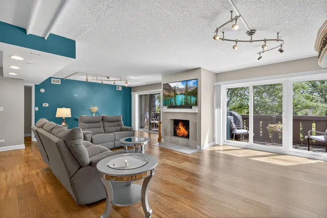 a living room with furniture a fireplace and a floor to ceiling window