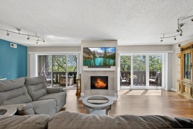 a living room with furniture a flat screen tv and a fireplace