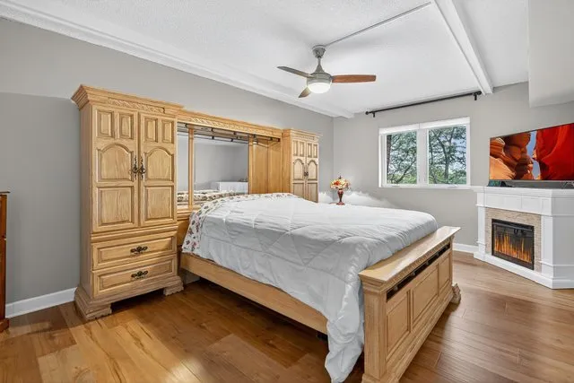 a spacious bedroom with a bed and a flat screen tv