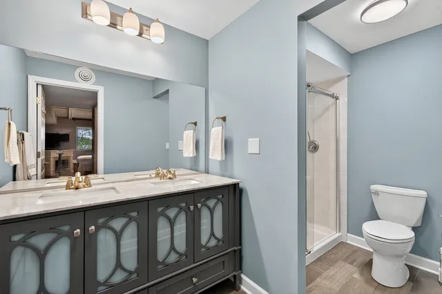 a bathroom with a granite countertop sink toilet and mirror