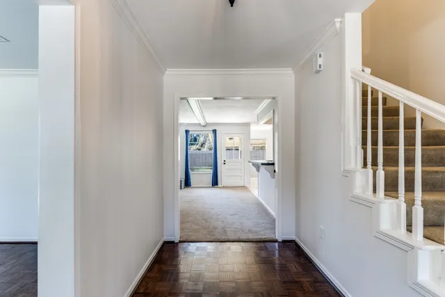 a view of a hallway with wooden floor and a living room