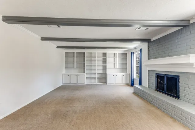 a view of an empty room with a fireplace and a window